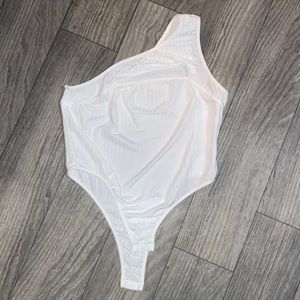 One shoulder body suit with chest cut out.